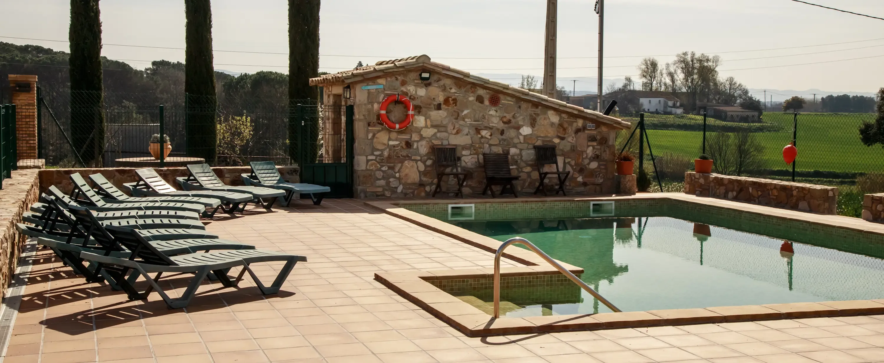 Piscina envoltada de terrassa de rajoles terracota